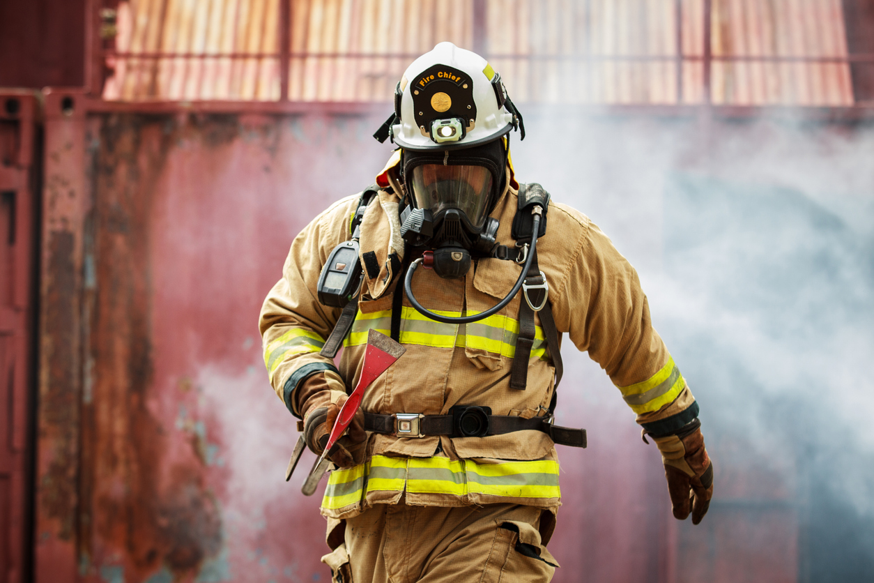 Firefighter walking back from a smoking building