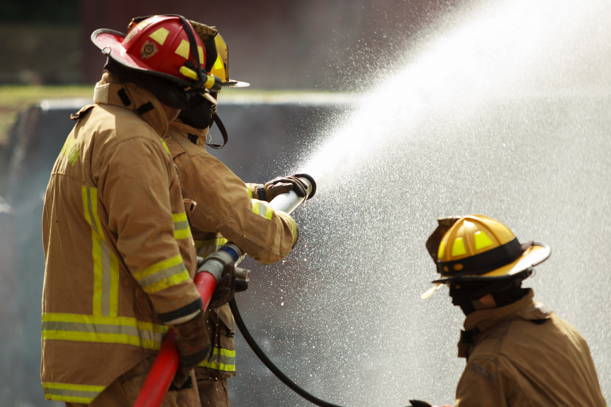Firefighters spraying a hose of water