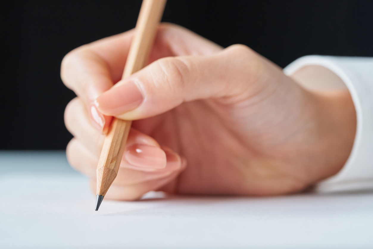 Person writing with a pencil